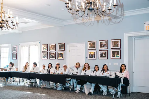 Turma do OTB reunida em volta da mesa longa de uma sala de reunião.